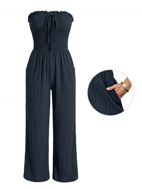 Combinaison de vacances unie texturée, à volants smockés, poche nouée, épaules dénudées et jambes larges.